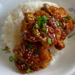 Garlic Soy Sauce Glazed Chicken on white rice with spring onions sprinkled on top, made on a pan with an easy recipe