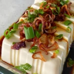 5 minute silken tofu with fried shallots and spring onions sprinkled on top, cooked on a pan with an easy recipe