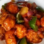 Sweet and sour chicken topped with capsicums, onions and pineapple. Made with an easy air fryer recipe from frozen chicken